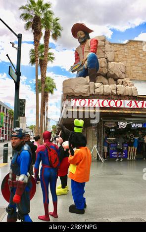 Statue de prospecteur d'or et personnages costumés comme Captain America Spiderman Dingo Mickey Mouse l'entrée de l'expérience Fremont Las Vegas Nevada USA Banque D'Images