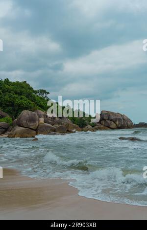 Vagues dansant au milieu de Rocky Shores, sous un ciel lunatique à Crystal Bay Beach, Koh Samui, Thaïlande Banque D'Images