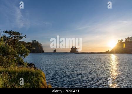 Vue panoramique sur le coucher du soleil avec des éclaires de soleil vues depuis la côte de la Push, WA, Etats-Unis avec vue sur les piles de mer et l'île James et Little Jam Banque D'Images