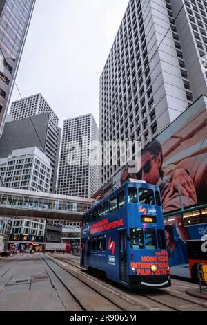 Hong Kong, Chine - avril 24 2023 : tramway à double pont entre un immeuble de bureaux de grande hauteur avec grand angle Banque D'Images