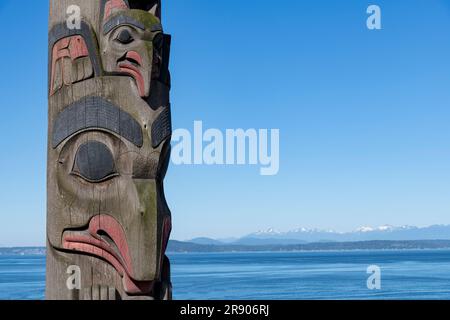 Seattle, WA, USA-juillet 2022 ; vue rapprochée d'une partie d'un totem le long du front de mer dans le parc Victor Steinbrueck avec des montagnes enneigées d'Olympii Banque D'Images