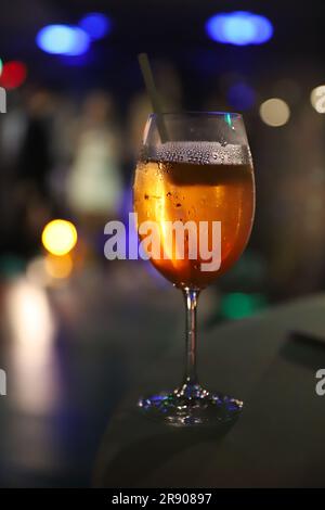 Boisson italienne typique d'origine, apéritif apéritif servi avec du vin blanc prosecco dans une ambiance bokeh à l'intérieur lumières disco Banque D'Images