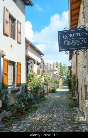 Mai 2023 Langhirano, Italie: Rues de la petite ville médiévale autour du château castello Torrechiara avec de vieilles maisons, panneaux Banque D'Images
