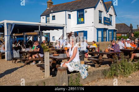 Whitstable Nord Kent , Angleterre UK - Tourisme féminin aime une bière à l'extérieur du célèbre pub Old Neptune sur le front de mer en plein soleil Banque D'Images