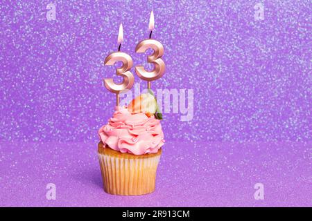 Cupcake avec numéro pour la célébration d'anniversaire ou d'anniversaire; numéro 33 Banque D'Images