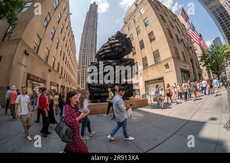 Les visiteurs du Rockefeller Center de New York mardi, 13 juin 2023 passent l'Issu du feu par l'artiste coréen Lee Bae, situé sur la Cinquième Avenue à la tête des jardins de la Manche. La sculpture de 21 pieds de haut est construite de pièces massives de charbon de bois en forme de troncs d'arbre et fait partie d'un spectacle célébrant la culture coréenne sur la vue jusqu'à 26 juillet. © Richard B. Levine) Banque D'Images