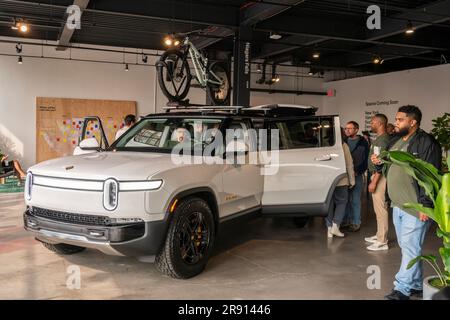 Les passionnés d'automobile assistent vendredi à l'inauguration d'une salle d'exposition Rivian Spaces dans le quartier de Meatpacking à New York, 16 juin 2023. Rivier s'est joint à d'autres fabricants de véhicules électriques de luxe Tesla, Genesis et lucide dans le quartier de Meatpacking. (© Richard B. Levine) Banque D'Images