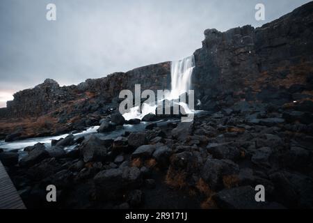 Une cascade entre la pierre noire dans le sud de l'Islande en octobre.photographiée avec une exposition de longue durée. Banque D'Images