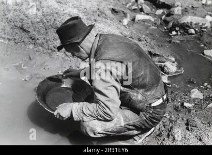 Pinos Altos, Nouveau-Mexique: Mai 1940 Un prospecteur recherche l'or. Les objets légers dans sa casserole ne sont probablement pas en or car il est très inhabituel de trouver des pièces de cette grande taille dans cette section. Il s'agit probablement de mica (or des sools) ou de mercure, qui est utilisé pour attirer l'or Banque D'Images