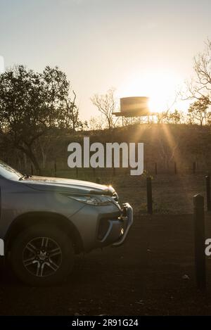 Le soleil se couche derrière un grand réservoir d'eau sur une colline près d'un terrain de camping dans l'Outback, en Australie occidentale Banque D'Images