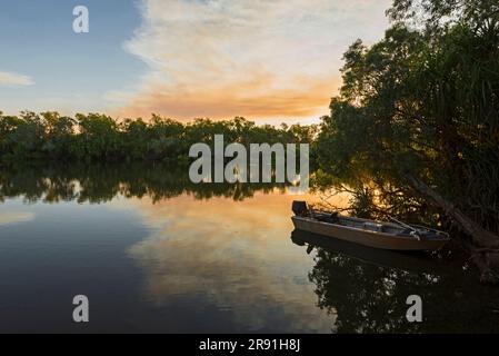 Un petit bateau en étain se trouve sur les eaux calmes de Jim Jim billabong à Kakadu, en Australie Banque D'Images