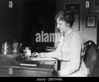 New York, New York: c. 1922 Une femme qui écrit à son bureau à l'hôtel McAlpin à New York. Banque D'Images