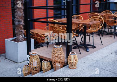 Plusieurs chaises en bois encerclent une table près d'un beau jardin Banque D'Images