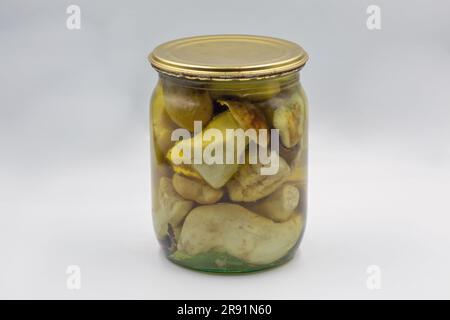 Pot en verre de champignons porcini marinés faits maison, gros plan sur du blanc. Banque D'Images