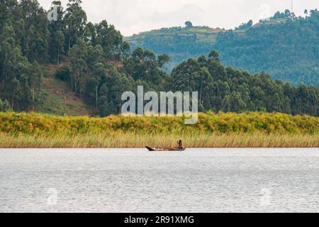 Un pêcheur sur un canot de pêche traditionnel au lac Mutanda, en Ouganda Banque D'Images