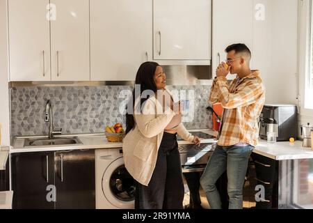 Couple prenant un café et passant du temps libre dans la cuisine Banque D'Images