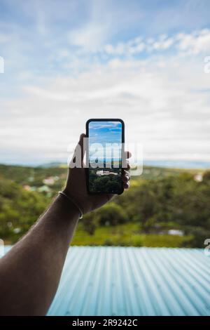 Main de l'homme en cliquant sur une photo de la nature à travers un smartphone Banque D'Images