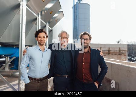 Homme d'affaires heureux debout avec des collègues de l'industrie Banque D'Images