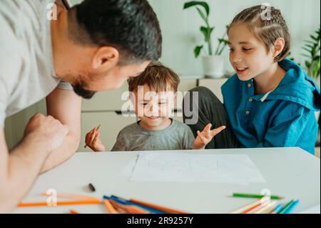 Père avec des fils qui s'amusent à faire des œuvres d'art à la maison Banque D'Images