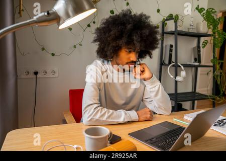 Travailleur indépendant concentré avec ordinateur portable sur le bureau à la maison Banque D'Images