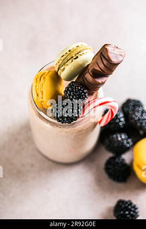Milk-Shake extrême au chocolat avec macarons, baies et bonbons. Tendance à la fréakshake. Copier l'espace Banque D'Images