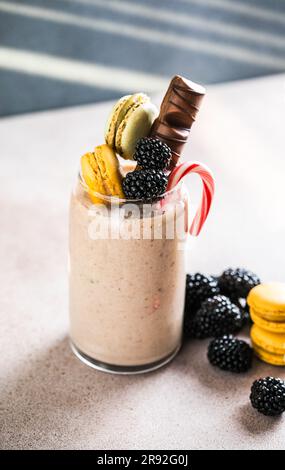 Milk-Shake extrême au chocolat avec macarons, baies et bonbons. Tendance à la fréakshake. Copier l'espace Banque D'Images