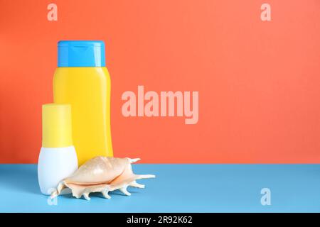 Différents produits de bronzage et de seashell sur fond de couleur. Espace pour le texte Banque D'Images