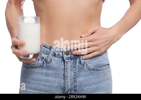 Femme avec un verre de lait souffrant d'intolérance au lactose sur fond blanc, gros plan Banque D'Images