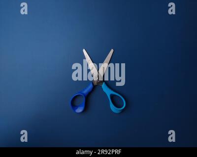 Vue de dessus ciseaux bleus sur fond bleu Banque D'Images