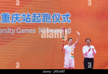 Chongqing. 24th juin 2023. Le porteur de la torche Li Xuerui (L) tient la torche pendant le relais de la torche des Jeux de l'Université mondiale d'été de la FISU de Chengdu 2021 à l'Université de Chongqing, dans la municipalité de Chongqing, dans le sud-ouest de la Chine, à 24 juin 2023. Credit: Liu Chan/Xinhua/Alay Live News Banque D'Images