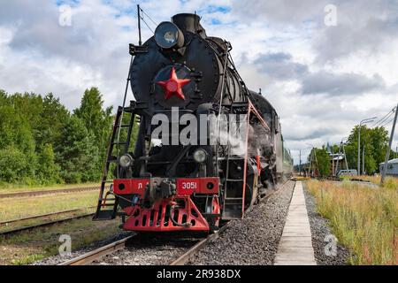 KUZHENKINO, RUSSIE - 16 JUILLET 2022 : ancienne locomotive à vapeur soviétique L-3051 (Lebedyanka) avec train rétro Seliger sur la gare de Kuzhenkino sur un juillet nuageux Banque D'Images