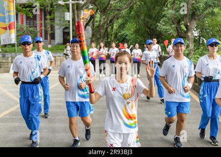 Chongqing. 24th juin 2023. Le porteur de la torche Yang Jiayu (C) fonctionne avec la torche pendant le relais de la torche des Jeux de l'Université mondiale d'été de la FISU de Chengdu 2021 à l'Université de Chongqing, dans la municipalité de Chongqing, dans le sud-ouest de la Chine, à 24 juin 2023. Credit: Huang Wei/Xinhua/Alay Live News Banque D'Images