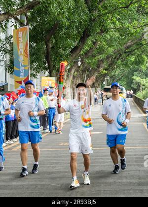 Chongqing. 24th juin 2023. Le porteur de la torche Yang Jian (C) fonctionne avec la torche pendant le relais de la torche des Jeux de l'Université mondiale d'été de la FISU de Chengdu 2021 à l'Université de Chongqing, dans la municipalité de Chongqing, dans le sud-ouest de la Chine, à 24 juin 2023. Credit: Huang Wei/Xinhua/Alay Live News Banque D'Images