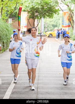 Chongqing. 24th juin 2023. Le porteur de la torche Wei Qiuyue (C) fonctionne avec la torche pendant le relais de la torche des Jeux de l'Université mondiale d'été de la FISU de Chengdu 2021 à l'Université de Chongqing, dans la municipalité de Chongqing, au sud-ouest de la Chine, à Chongqing, en 24 juin 2023. Credit: Huang Wei/Xinhua/Alay Live News Banque D'Images