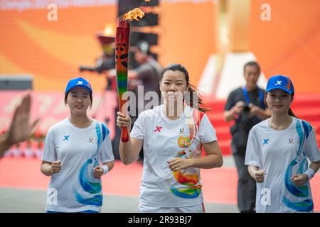 Chongqing. 24th juin 2023. Le porteur de la torche Li Xuerui (C) fonctionne avec la torche pendant le relais de la torche des Jeux de l'Université mondiale d'été de la FISU de Chengdu 2021 à l'Université de Chongqing, dans la municipalité de Chongqing, dans le sud-ouest de la Chine, à 24 juin 2023. Credit: Huang Wei/Xinhua/Alay Live News Banque D'Images
