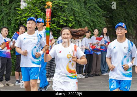 Chongqing. 24th juin 2023. Le porteur de la torche Xie Yue (C) fonctionne avec la torche pendant le relais de la torche des Jeux de l'Université mondiale d'été de la FISU de Chengdu 2021 à l'Université de Chongqing, dans la municipalité de Chongqing, dans le sud-ouest de la Chine, à 24 juin 2023. Credit: Huang Wei/Xinhua/Alay Live News Banque D'Images