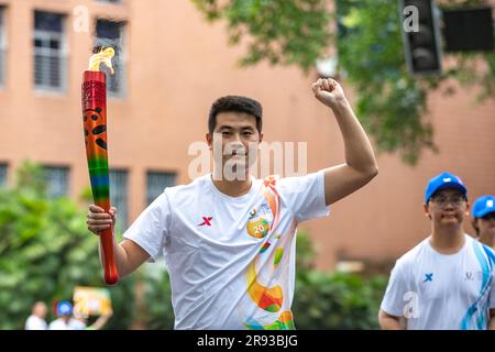 Chongqing. 24th juin 2023. Le porteur de la torche Huang Fawei (L) fonctionne avec la torche pendant le relais de la torche des Jeux de l'Université mondiale d'été de la FISU de Chengdu 2021 à l'Université de Chongqing, dans la municipalité de Chongqing, dans le sud-ouest de la Chine, à 24 juin 2023. Credit: Huang Wei/Xinhua/Alay Live News Banque D'Images