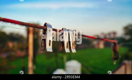 Gros plan des épingles à linge sur le toit, des crochets à linge sur une corde. Pinces à linge monochromes ou pinces à linge en acier inoxydable. Mise au point sélective. Banque D'Images