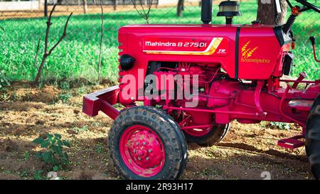 Agriculteur en tracteur préparant des terres agricoles avec un lit de semence pour la prochaine récolte. Détails du tracteur rouge moderne gros plan, vue latérale, pneus noirs Banque D'Images