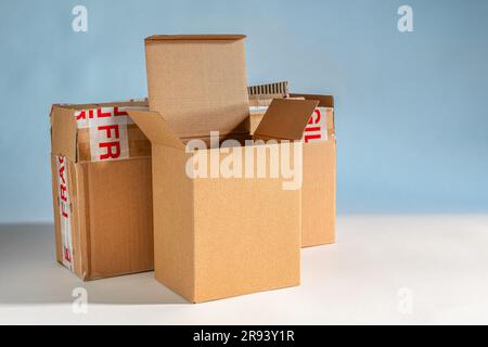 Boîte en carton vide isolée sur fond bleu et blanc Banque D'Images