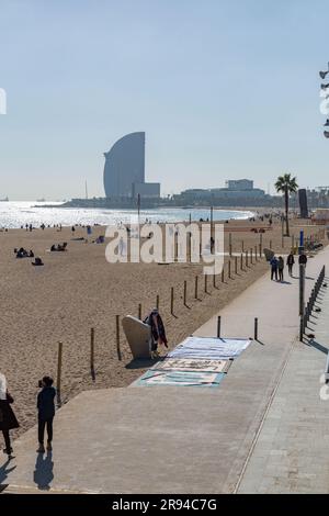 Barcelone, Espagne - 10 FÉVRIER 2022 : vendeurs illégaux de vêtements de plage sur la plage de Barceloneta. Banque D'Images