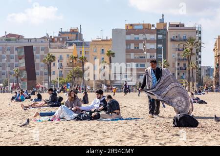 Barcelone, Espagne - 10 FÉVRIER 2022 : vendeurs illégaux de vêtements de plage sur la plage de Barceloneta. Banque D'Images