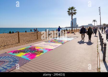 Barcelone, Espagne - 10 FÉVRIER 2022 : vendeurs illégaux de vêtements de plage sur la plage de Barceloneta. Banque D'Images