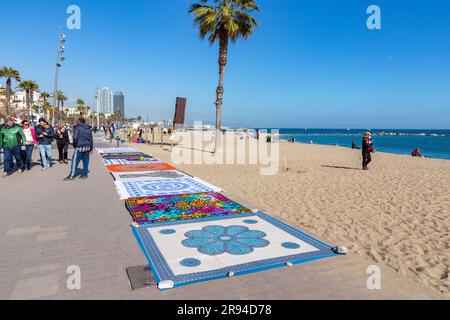 Barcelone, Espagne - 10 FÉVRIER 2022 : vendeurs illégaux de vêtements de plage sur la plage de Barceloneta. Banque D'Images