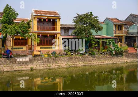 Un étang avec une rangée de maisons traditionnelles au bord de l'eau dans la vieille ville de Hoi an, Vietnam. Banque D'Images