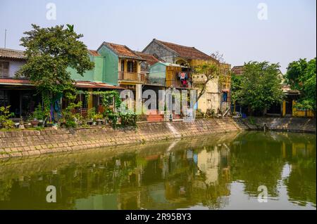 Un étang avec une rangée de maisons traditionnelles au bord de l'eau dans la vieille ville de Hoi an, Vietnam. Banque D'Images
