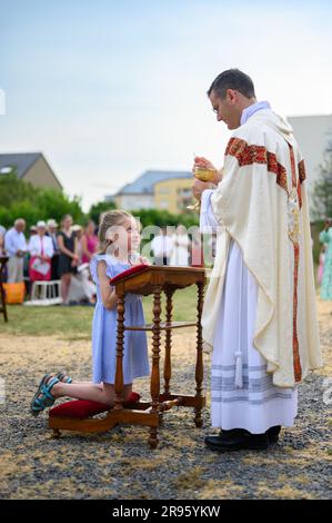 Un enfant recevant la première communion sainte. Banque D'Images