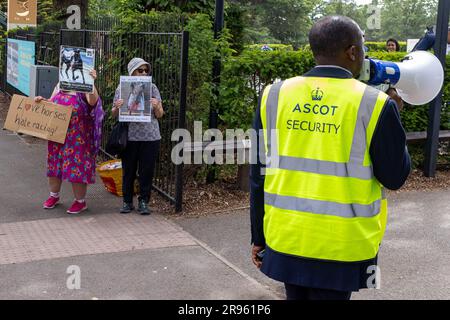 Ascot, Royaume-Uni. 24th juin 2023. Un agent de sécurité d'Ascot utilise un loudhailer pour noyer deux militants des droits des animaux qui protestent devant l'hippodrome d'Ascot alors que les racégers arrivent pour la cinquième journée de Royal Ascot. 28 chevaux sont morts dans des sauts et des courses à plat à Ascot entre 2012 et 2022. Crédit : Mark Kerrison/Alamy Live News Banque D'Images