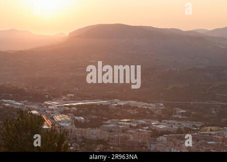 Paysage urbain d'Alcoy avec ses montagnes en arrière-plan pendant le lever du solstice d'été, Espagne Banque D'Images