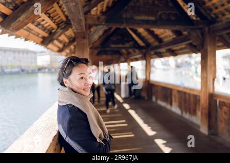 Une femme debout sur le pont de la Chapelle. Le pont de la Chapelle est un pont couvert en bois qui enjambe la rivière Reuss en diagonale dans la ville de Lucerne en cent Banque D'Images